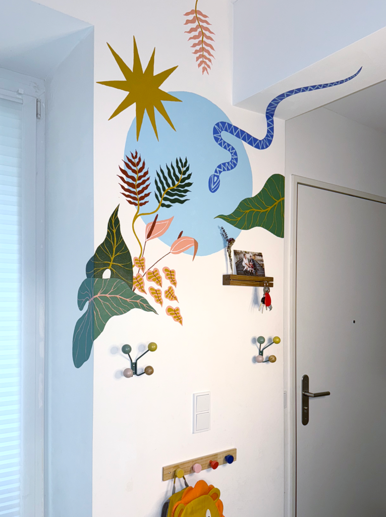 Hand-painted botanical mural with oversized tropical leaves, a blue snake and abstract sun in a modern home entryway.